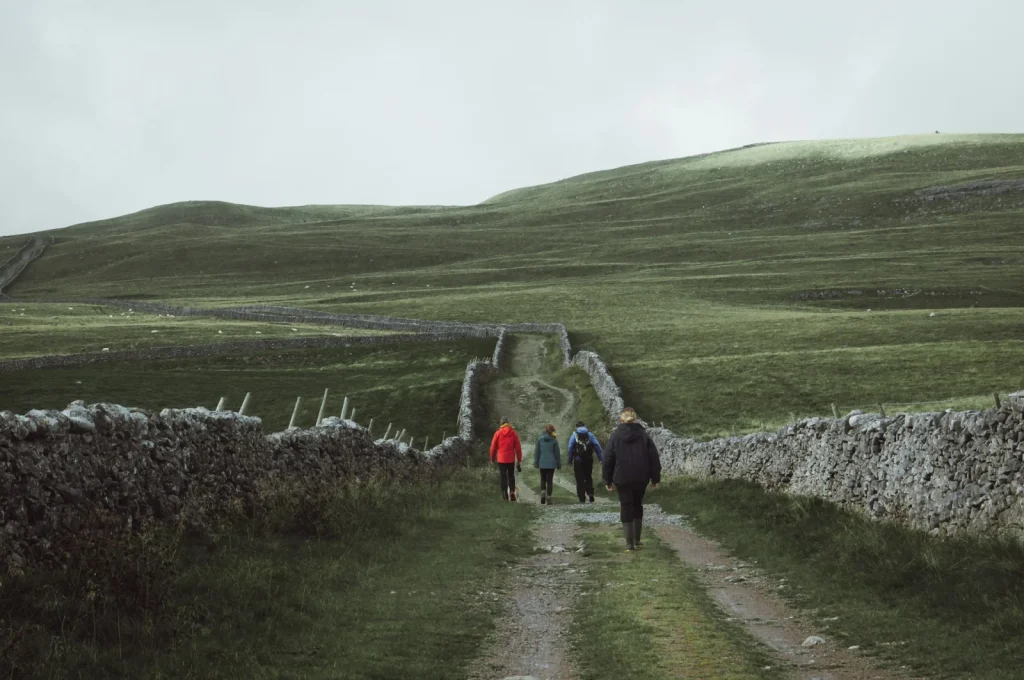 Groupe de randonneurs sur un chemin de collines, illustration du tourisme social et solidaire